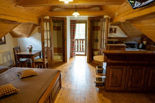 a room with a bed and a kitchen and a table at Zrub Raj in Liptovský Ján