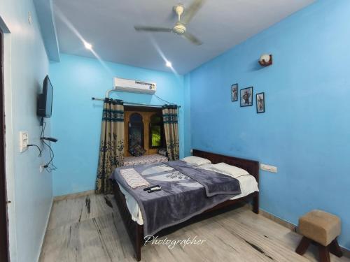 een blauwe kamer met een bed en een televisie bij Fort View Palace in Jodhpur