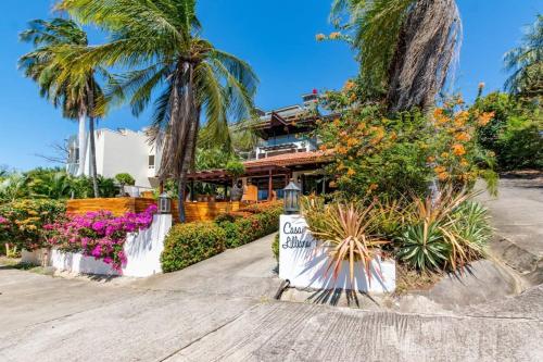 a house with palm trees and flowers on a street at Luxury Flamingo home with ocean view sleeps 10 - walking distance from beach in Playa Flamingo