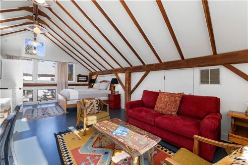 a living room with a red couch and a bed at Berrywood Loft in Lakeside