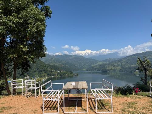 ポカラにあるBegnas horizonの湖の景色を望むテーブルと椅子