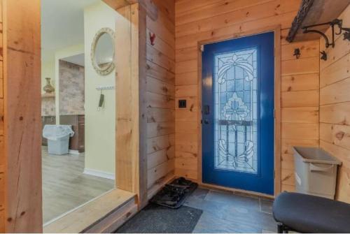 a room with a blue door in a wooden wall at Riverview Cottage Escape in Frankford