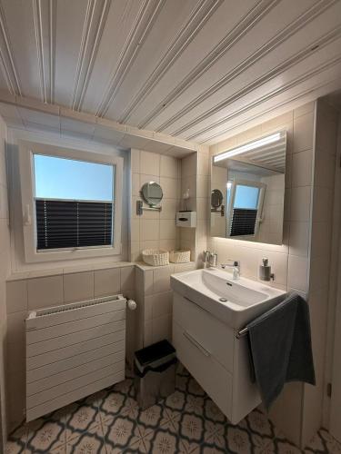 a white bathroom with a sink and a window at O Rendez Vous maison mitoyenne Piscine chauffée mars-octobre in Grimisuat