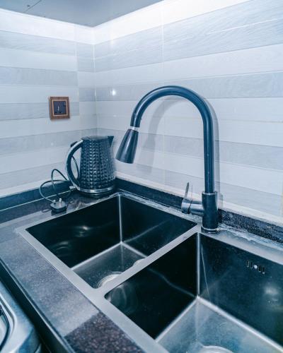 a kitchen sink with a faucet over it at Urban Haven in Kigali