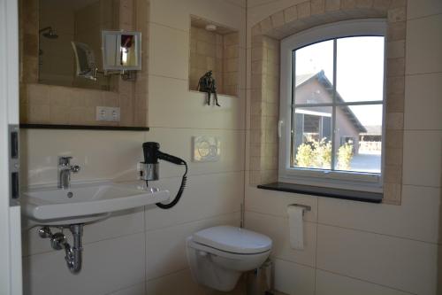 een badkamer met een wastafel, een toilet en een raam bij Wir Beide in Elten