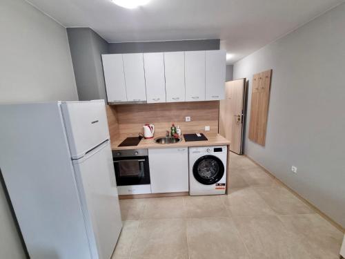 a kitchen with a white refrigerator and a washing machine at Flex loft in Sofia