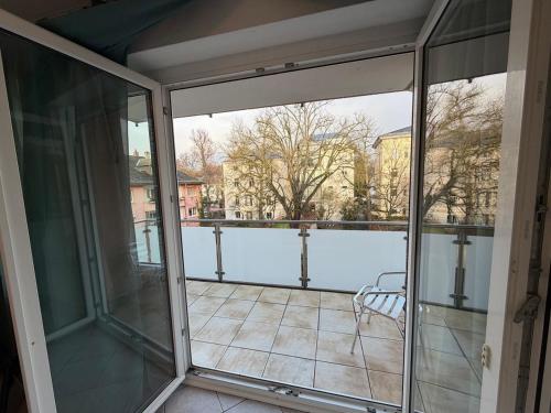 ein Balkon mit Glastüren und einem Tisch und Stühlen in der Unterkunft MonoApartment in Frankfurt am Main