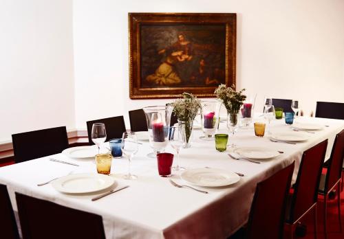 a long table with white plates and wine glasses at Hotel Villa Emilia in Barcelona