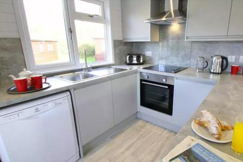 a kitchen with white appliances and a plate of food at 4 Bedroom Select Lodge with Park Facilities in Milford on Sea
