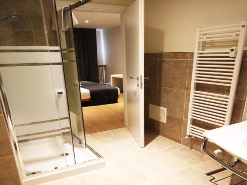 a bathroom with a glass shower and a bedroom at Verona Center in Verona