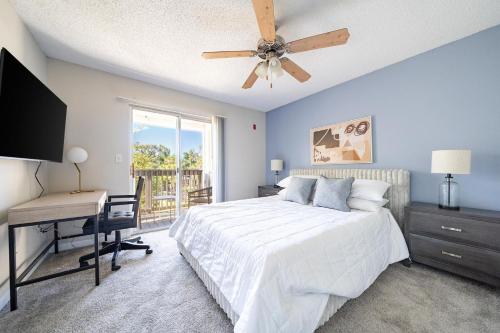 Schlafzimmer mit einem Bett, einem Schreibtisch und einem Deckenventilator in der Unterkunft Landing Amazing 1BD Tennis Court Gym in Palm Bay