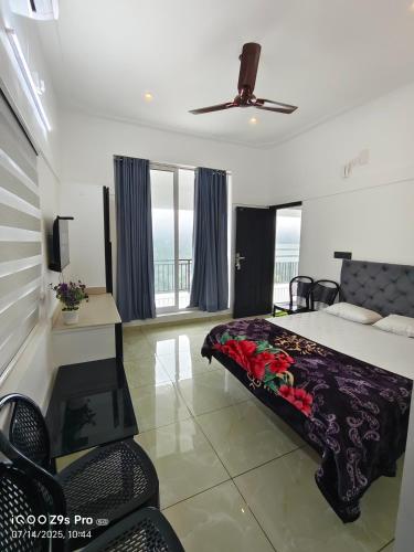 a bedroom with a bed and a table and chairs at Thazhvaram Pool Villa Idukki Calvary Mount in Idukki