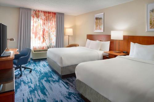 a hotel room with two beds and a desk at Fairfield Inn & Suites by Marriott Frederick in Frederick