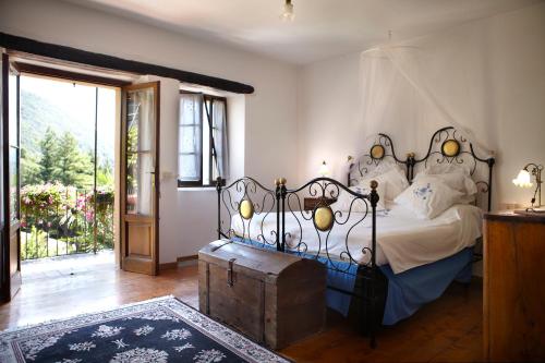 a bedroom with a bed with a wrought iron headboard at Antico Borgo Sanda Lago Maggiore in Casalzuigno
