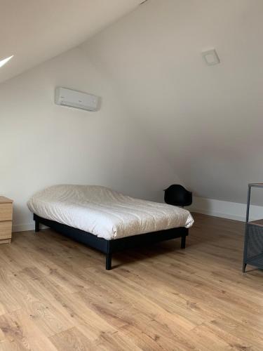 BlanzyAppartement F2 de 55 m2的卧室位于客房的角落,配有一张床