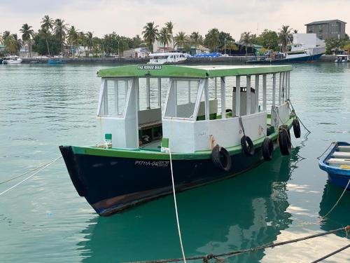 Un barco está atracado en un muelle en el agua. en Velidhoo Inn, en Velidhoo
