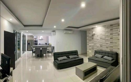 Una sala de estar con dos sofás y un comedor. en Casa Hannia 30 huéspedes Cerca de la playa Alberca, en Acapulco