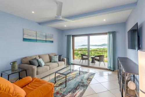 a living room with a couch and a table at 2-Bedroom Condo with Ocean View and Pool in Playa Flamingo