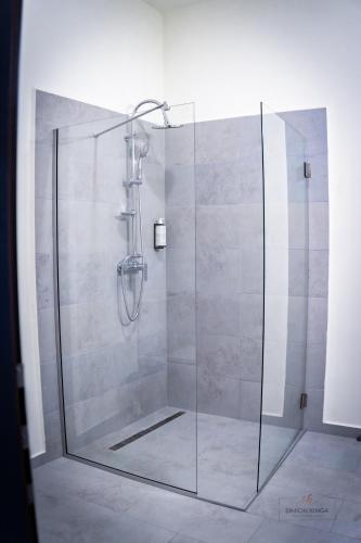 a shower with a glass door in a bathroom at Urban76 Apartments in Târgu-Mureş