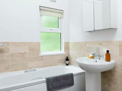 ein Badezimmer mit Waschbecken und Badewanne und Waschbecken in der Unterkunft Merley Woodland Signature 2 Lodge with Hot Tub in Wimborne Minster