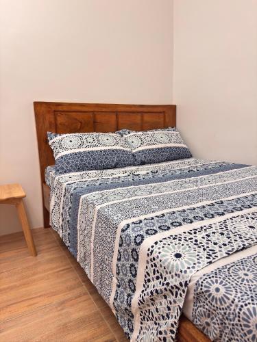 a bedroom with a bed with a blue and white comforter at Casa Tres16 - Your Private Cozy Retreat in Pilar