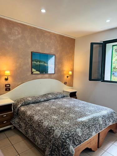a bedroom with a large bed and two windows at Hotel Federico II in Naples