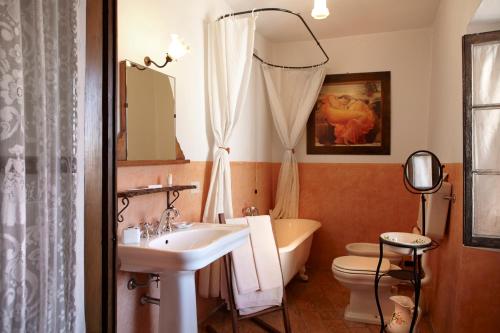 a bathroom with a sink and a toilet and a tub at Antico Borgo Sanda Lago Maggiore in Casalzuigno