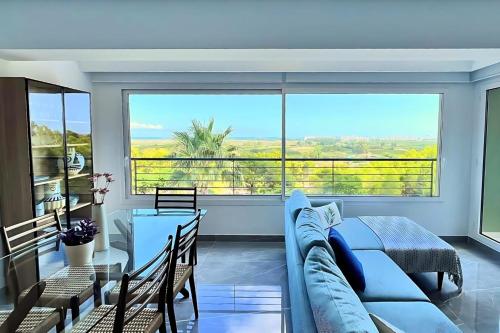 a living room with a couch and a large window at Superb penthouse swimming pools equipped solarium panoramic view in Xeresa