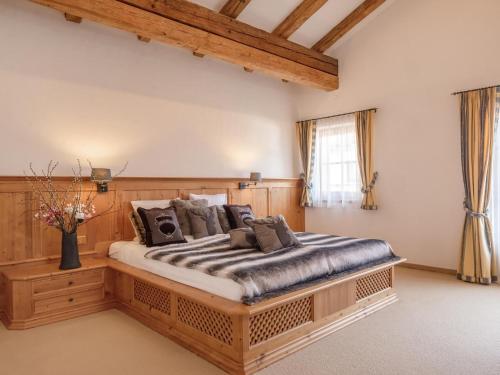 a bedroom with a large wooden bed with pillows at Kitzlodge S in Apfeldorf
