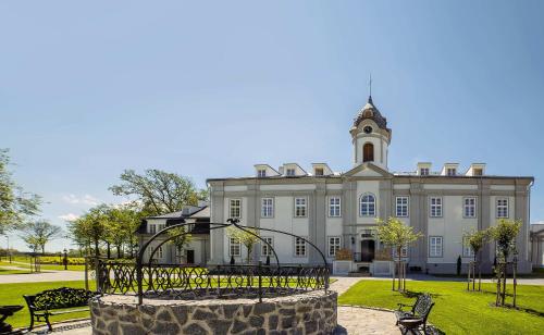 a large building with a clock tower on top of it at Hotel Panství Dlouhá Lhota in Dlouhá Lhota