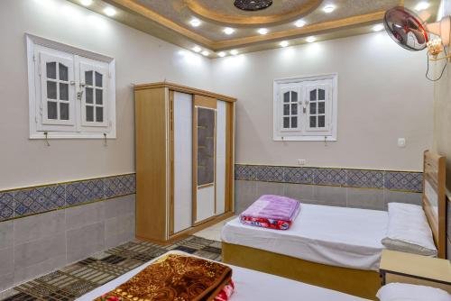 una habitación con dos camas y un armario en شاليه سيوة - Chalet Siwa, en Siwa