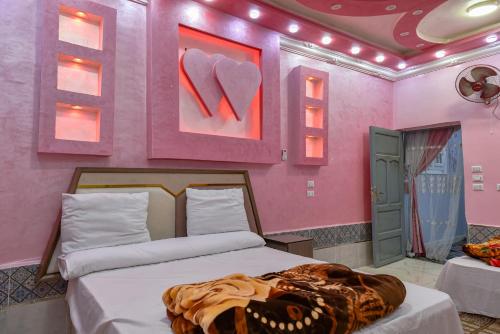 a bedroom with a bed in a pink room at شاليه سيوة - Chalet Siwa in Siwa