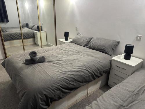 a bedroom with a large bed and a mirror at East Croydon Comfort Apartments in Croydon