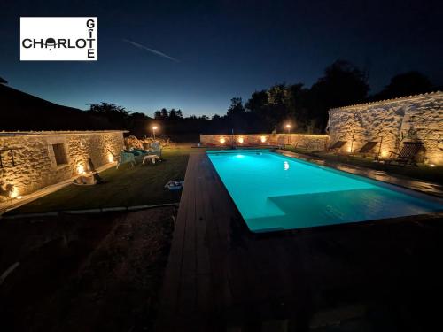 a large swimming pool in a yard at night at Gîte Charlot - Proche Futuroscope Aquascope in Migné-Auxances