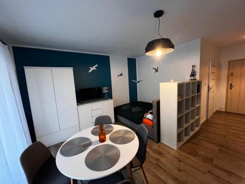 ein Wohnzimmer mit einem Tisch und ein Esszimmer in der Unterkunft Studio Mewa in Świnoujście