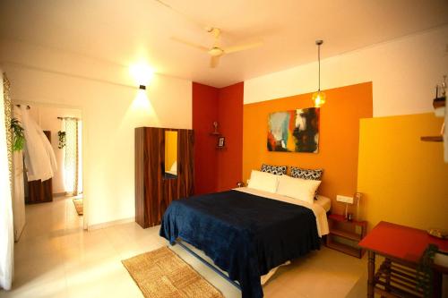 Un dormitorio con paredes naranjas y una cama dentro. en Amber Studio, en Canacona