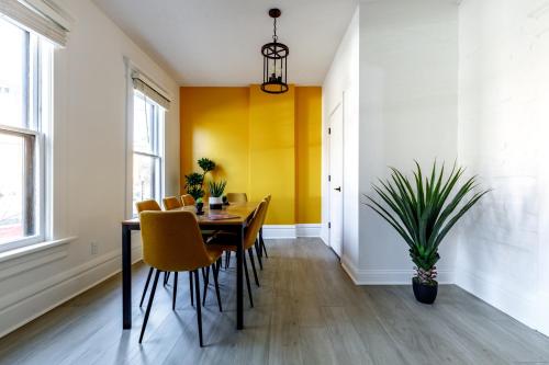 uma sala de jantar com paredes amarelas e uma mesa e cadeiras em Short North Convention King Bed Free Parking! em Columbus