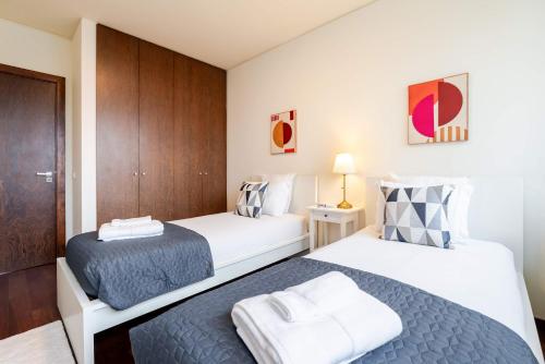 a bedroom with two beds and a closet at Modern & Spacious Flat with Garage by HostWise in Vila Nova de Gaia