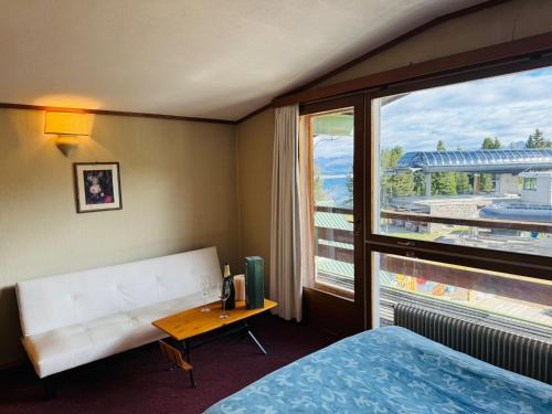 una camera d'albergo con un letto e una grande finestra di Eurotel Cermis a Cavalese