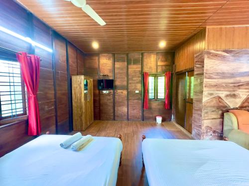 Un dormitorio con dos camas en una habitación. en Karlad Lake Palace Waterfront Resort by stayRAa, en Tariyod