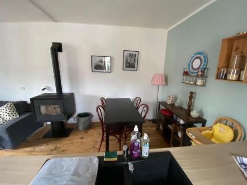 a living room with a couch and a stove at La maison à la porte bleue in Voutezac