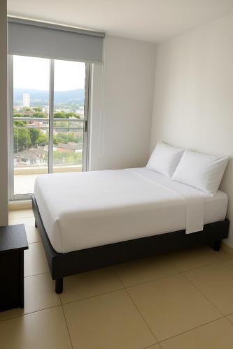 La vida es bella! hermoso apartamento con piscina cerca al centro de pereira في Dosquebradas: سرير أبيض في غرفة مع نافذة كبيرة