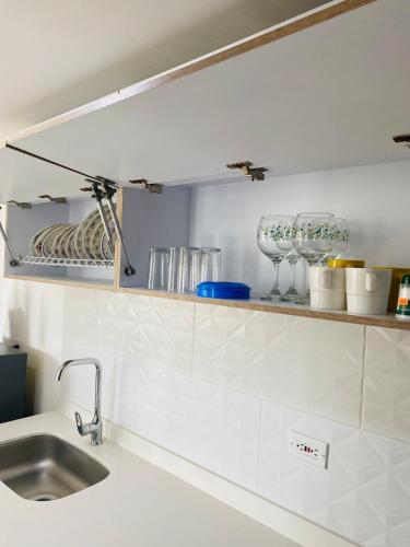 La vida es bella! hermoso apartamento con piscina cerca al centro de pereira في Dosquebradas: مطبخ مع حوض ورف مع نظارات