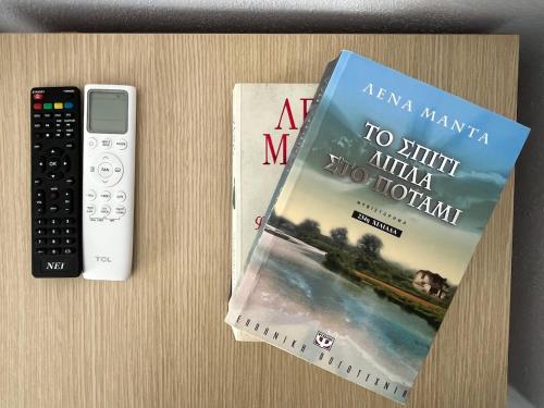 a book and a remote control sitting on a table at Elenis House in Leptokaria