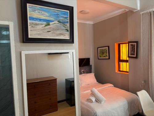 a small bedroom with a bed and a mirror at The Elegant Retreat of The Silver Room in Johannesburg