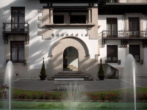 a building with a fountain in front of it at Palacio Arias in Navia