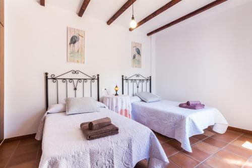 Casa lorenzo في Nigüelas: سريرين في غرفة بجدران بيضاء
