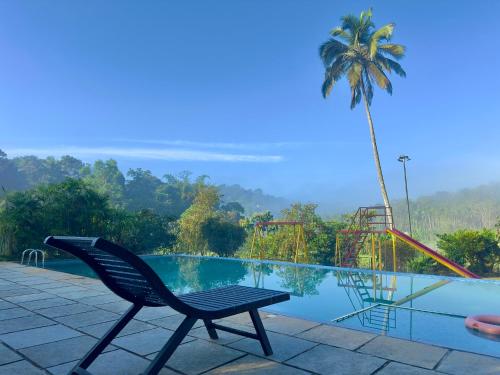 Una silla junto a una piscina con zona de juegos en Karlad Lake Palace Waterfront Resort by stayRAa, en Tariyod