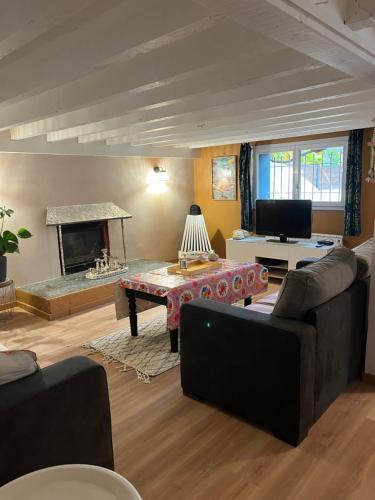 een woonkamer met een bank en een open haard bij Belle suite Un petit voyage au calme à 10 mnCV de Béziers entrée indépendante in Béziers