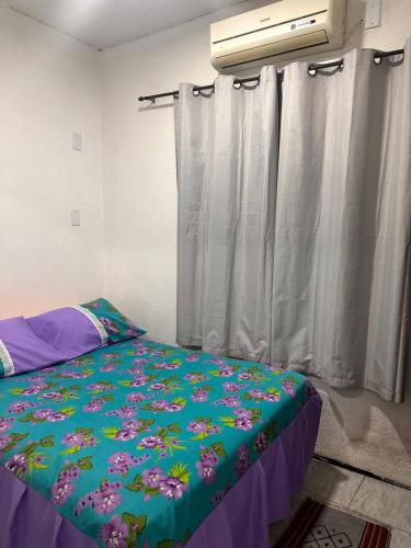 a bedroom with a bed with a blue comforter at Flat Serra Grande in Viçosa do Ceará